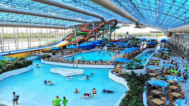 Un parc aquatique intérieur doté de plusieurs piscines, de toboggans et d’un grand toboggan aquatique.