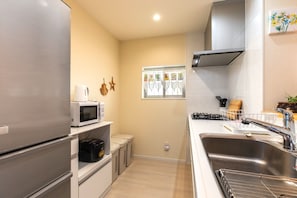 Enjoy cooking in this well-equipped kitchen with a refrigerator, microwave, oven, sink, and gas stove.