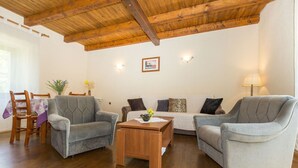 A living room with two grey armchairs, a wooden coffee table, and a sofa with patterned cushions. - Apartment Justina-Labin-quiet place (Sveta Nedelja)