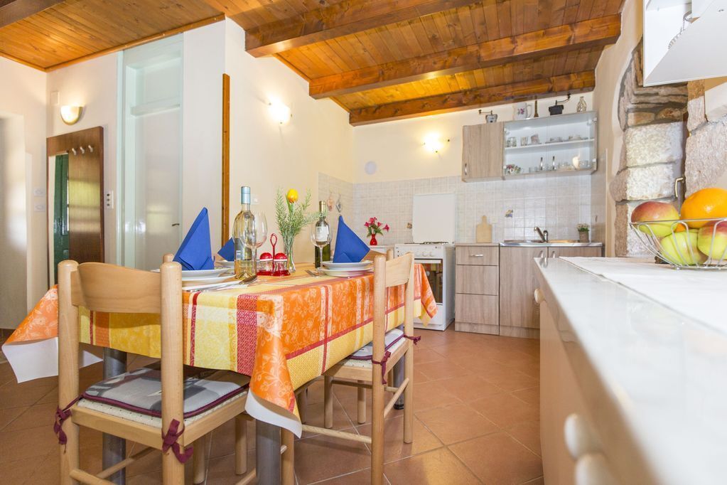 Un comedor con techo de madera, una cocina con detalles de piedra y un frutero en la encimera.