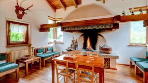 Un interior rústico con chimenea, muebles de madera y un techo con vigas a la vista.