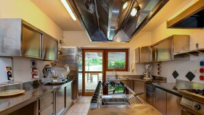 Una cocina moderna con electrodomésticos de acero inoxidable, una encimera amplia y vistas al exterior a través de un ventanal.