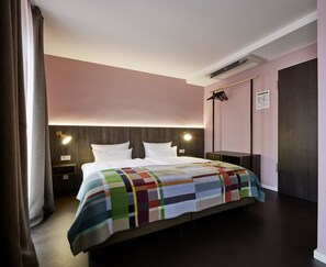 A hotel room with a bed, bedside tables, a wall-mounted TV, and a wardrobe. - Central Hotel Münster (Münster)