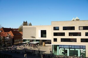 A public square with a modern building featuring large windows and a patterned facade. - Central Hotel Münster (Münster)