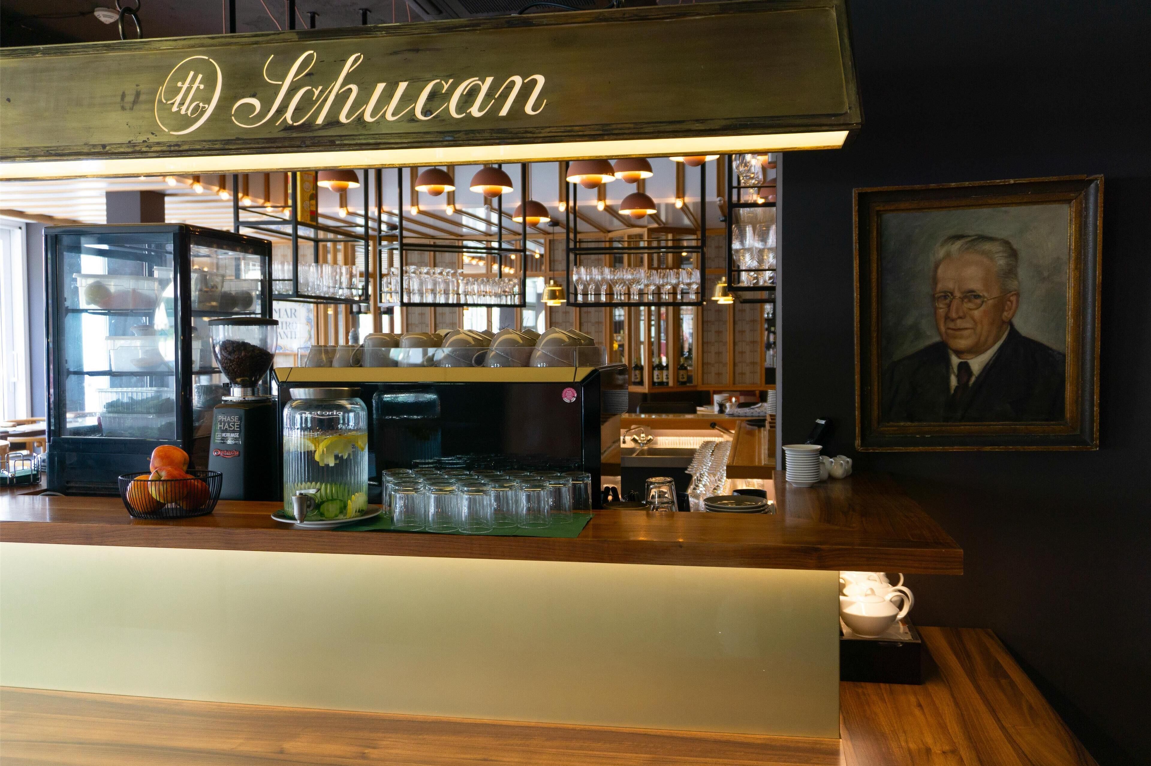 A bar area with a counter, glasses, and a coffee machine.