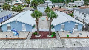 Zona residencial con dos edificios azules, palmeras y un parque infantil.