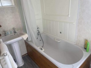 Chalet | Badkamer | Een bad/douchecombinatie, een diep bad, gratis toiletartikelen