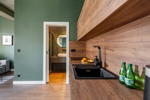 Une salle de bain moderne avec un meuble-lavabo en bois, un évier et un miroir. On peut voir deux bouteilles vertes sur le comptoir.