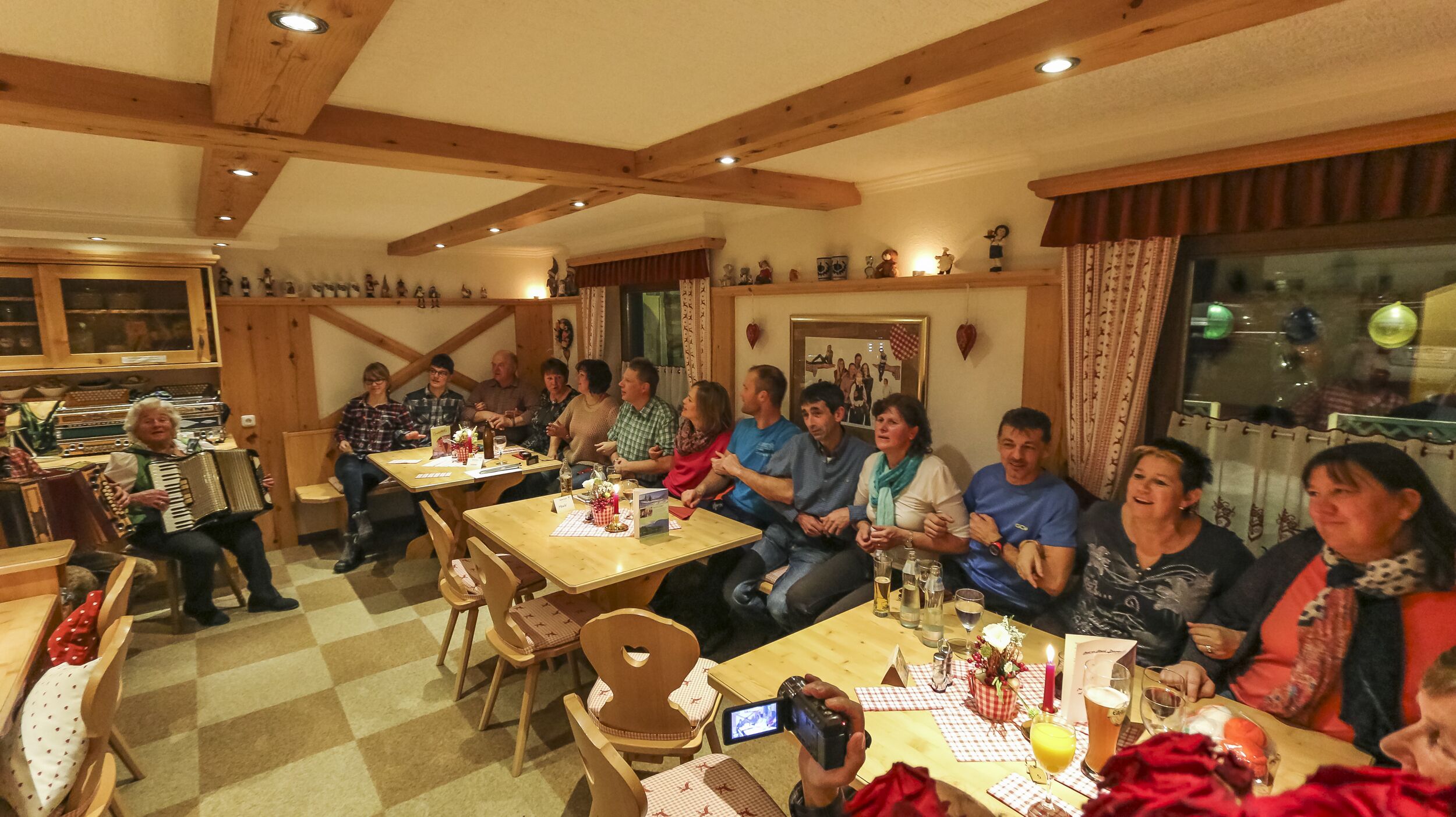 Ein gemütliches Restaurant mit Holzbalken, Schachbrettfußboden und einer Gruppe von Dinierenden.