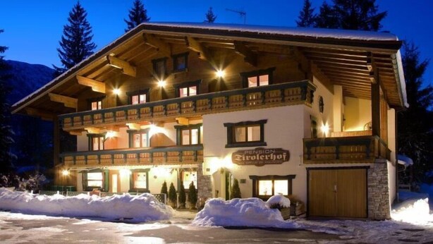 A two-story wooden building with a sign reading "Pension Girodchopf." - Tirolerhof (St. Ulrich Am Pillersee)