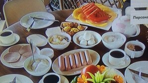 A table set with various dishes, including a watermelon, bread, and a fruit salad. - Gio 350 (Kobuleti)