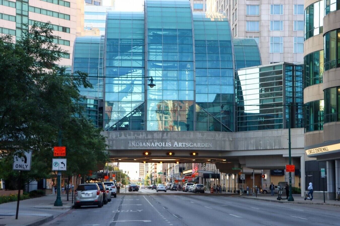 A modern building with a glass facade and a sign for Indianapolis Artsgarden.