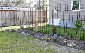 Stroll through the beautifully maintained garden, surrounded by a variety of flowering plants and shrubs in raised beds.