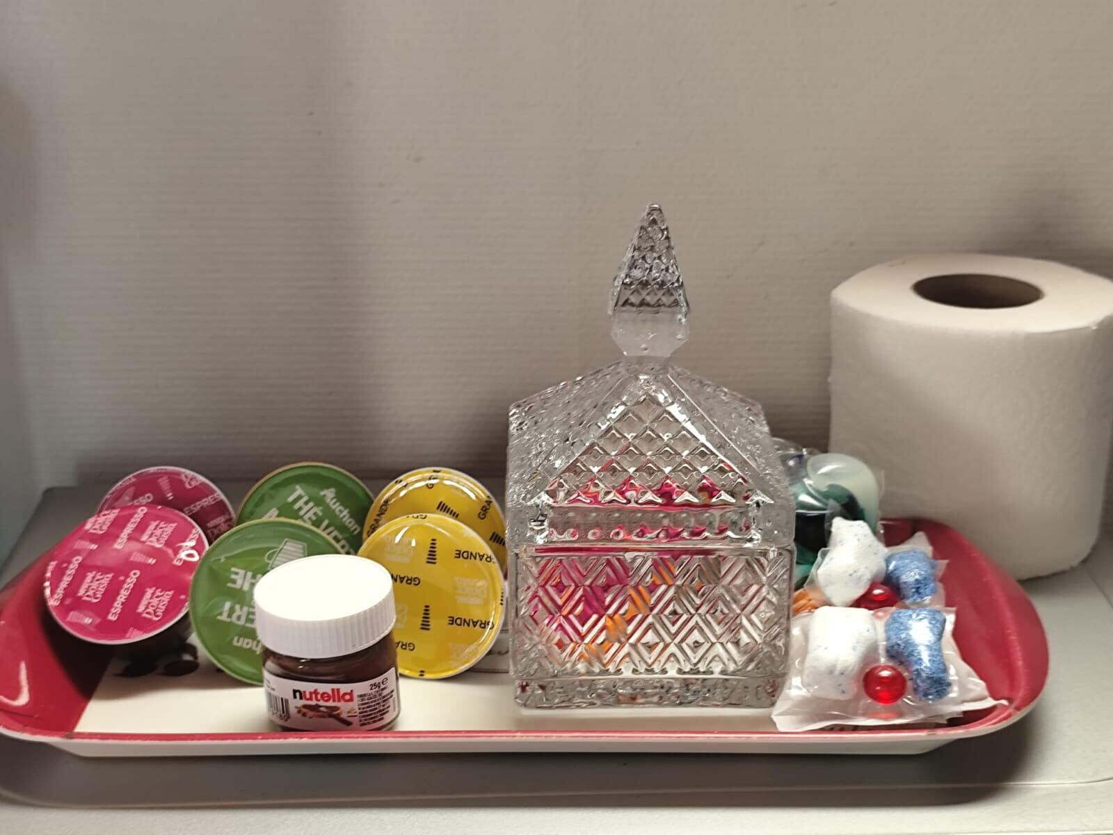 Un plateau contenant divers aliments, un bocal de Nutella et un rouleau de papier toilette.