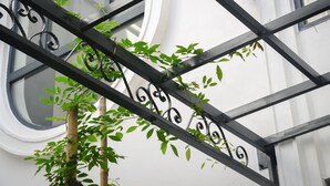 A metal balcony structure with green plants growing through it. - Momali Hotel Ninh Binh (Hoa Lu)