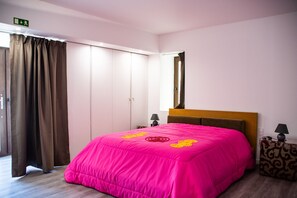 Ein Schlafzimmer mit Bett, Schrank, Nachttisch und Spiegel.