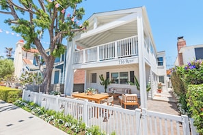A two-story house with a balcony, a dining area, and a porch.