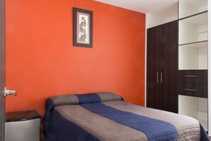 Cubrecamas, muebles diferentes y espacio para trabajar con laptop 