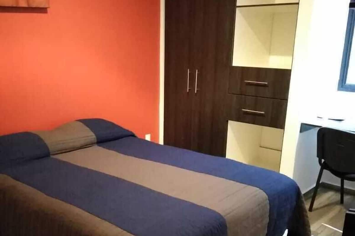 Habitación básica | Edredón, muebles diferentes y espacio para trabajar con laptop