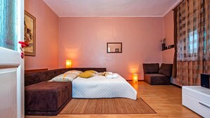 A bedroom with a bed, a sofa, a bedside table, a lamp, and a mirror. - STELA - One Bedroom Apartment (Rovinj)