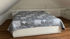 Een slaapkamer met een bed, nachtkastjes en een kledingkast.