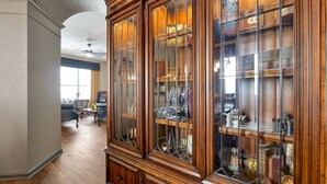 A spacious room with a large wooden cabinet filled with various items.