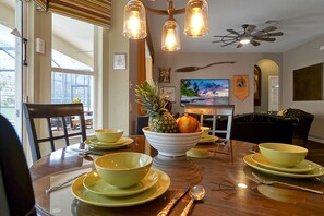 Enjoy meals in this dining area with a table set for a meal, featuring a television and comfortable seating.