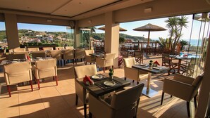 A restaurant with outdoor seating, tables, chairs, and umbrellas. - Terezas Hotel (Corfu)