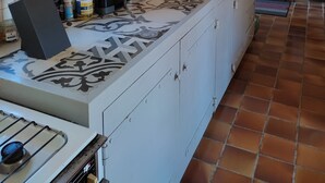 A kitchen with a tiled backsplash, wooden ceiling beams, a stove, and various kitchen utensils. - Between Sainte Marie de Campan and La Mongie. (Campan)