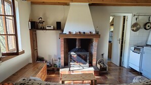 A cozy living room with a fireplace, wooden furniture, and a view of the kitchen. - Between Sainte Marie de Campan and La Mongie. (Campan)