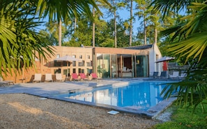 A modern building with a swimming pool, outdoor seating, and palm trees. - When heritage, art and well-being meet (CANDES SAINT MARTIN)