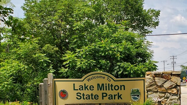 A welcome sign for Lake Milton State Park with a stone wall and greenery. - Sunset cottage complete w/large deck, fire pit and mins away from public beach (Lake Milton)