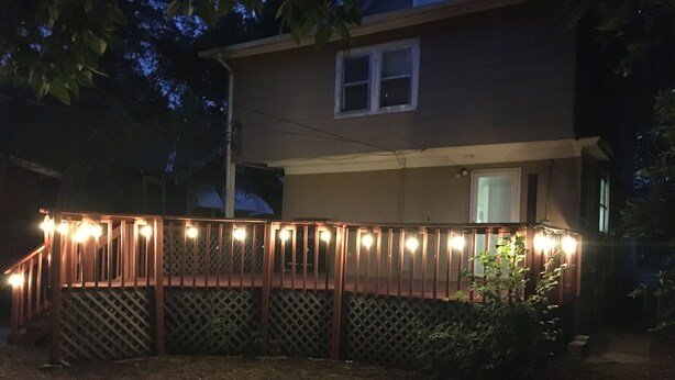 A house with a wooden deck and a lattice fence. - Charming Colonial Home with Private Chipping Green (Hutchinson)