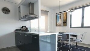 A modern kitchen with a central island, stainless steel appliances, and a dining area with a table and chairs.