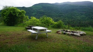 A picnic table in a grassy area with a view of a forested mountain range. - The Mighty Fraser Motel (Boston Bar)