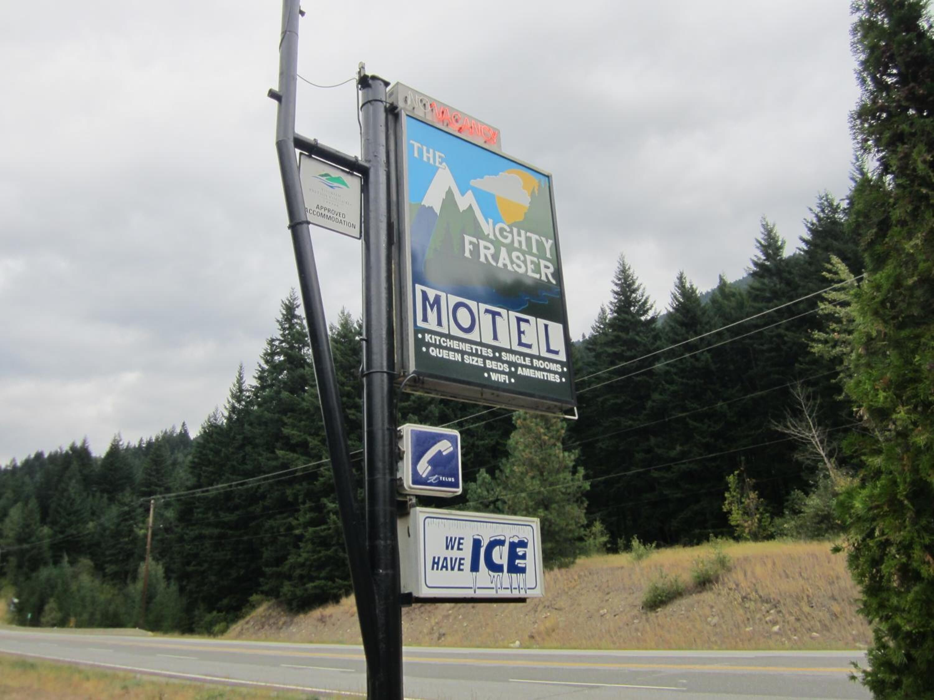 A motel sign with amenities including kitchenettes, single rooms, queen size beds, and WiFi.