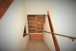 Una escalera con escalones de madera y una puerta de madera al final.