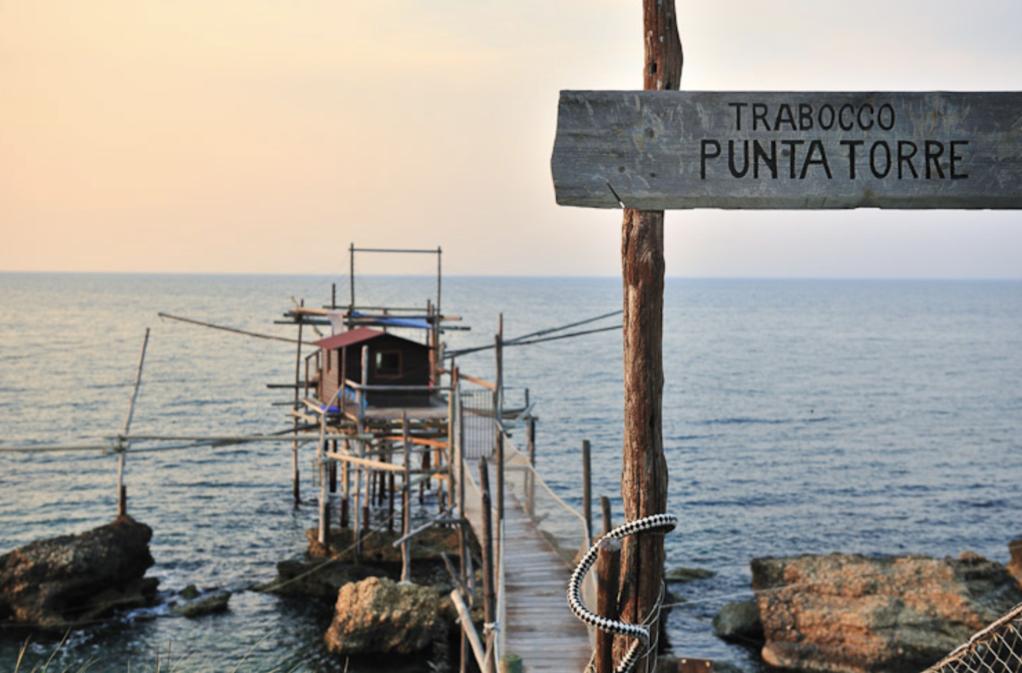 A wooden signpost with the text 'TRABOCCO PUNTA TORRE' indicating a location.