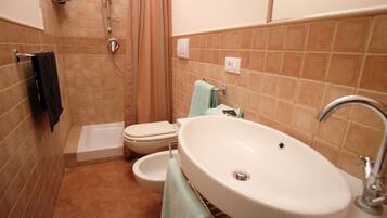 Un bagno con vasca, water, bidet e lavandino.