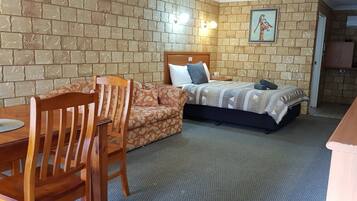 Relax in this inviting room with a comfortable bed, a nightstand, and a small table for work or reading.