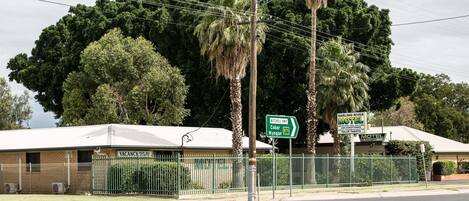 Un motel con patio cercado, un cartel que indica las indicaciones para Darling River Motel y Mitchell Hwy.