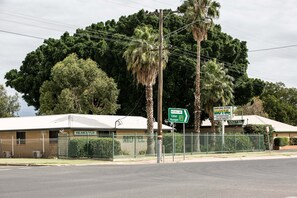 A motel with a fenced yard, a sign indicating directions to Darling River Motel and Mitchell Hwy.