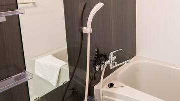 Une salle de bain moderne équipée d’une baignoire, d’une douche et d’un porte-serviettes.