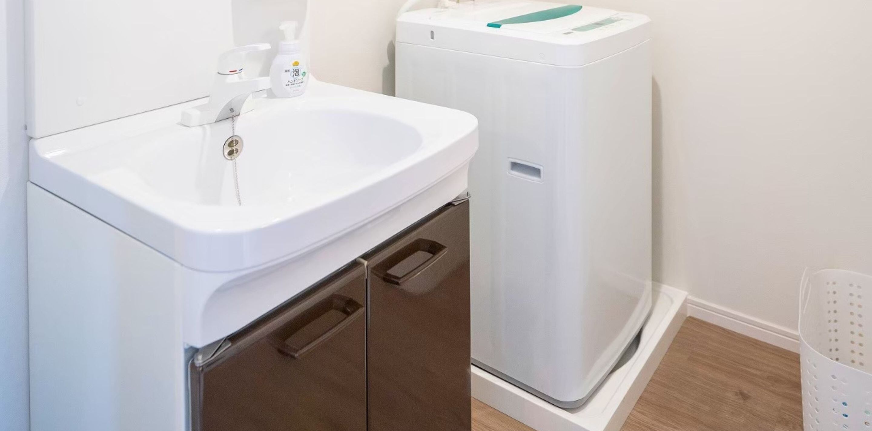 A bathroom with a white sink, a mirror, and a white toilet.