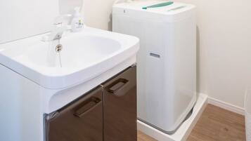 A bathroom with a white sink, a mirror, and a white toilet.