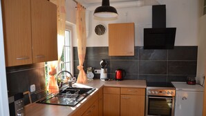 A modern kitchen with wooden cabinets, a stainless steel oven, a coffee maker, and a kettle. - Family-friendly, Black Forest Nature Park Murg Valley Baden Baden Hiking vacation  (Weisenbach)