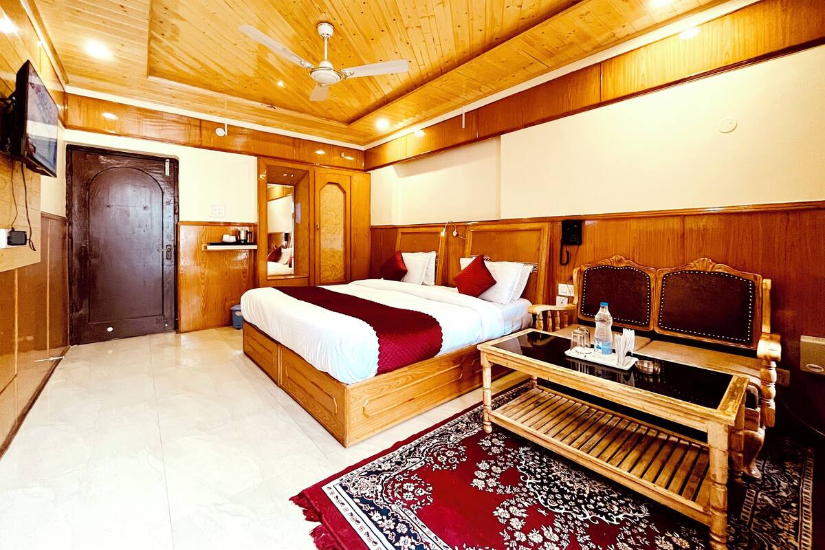 A wooden-paneled bedroom with a bed, bedside table, and a mirror.