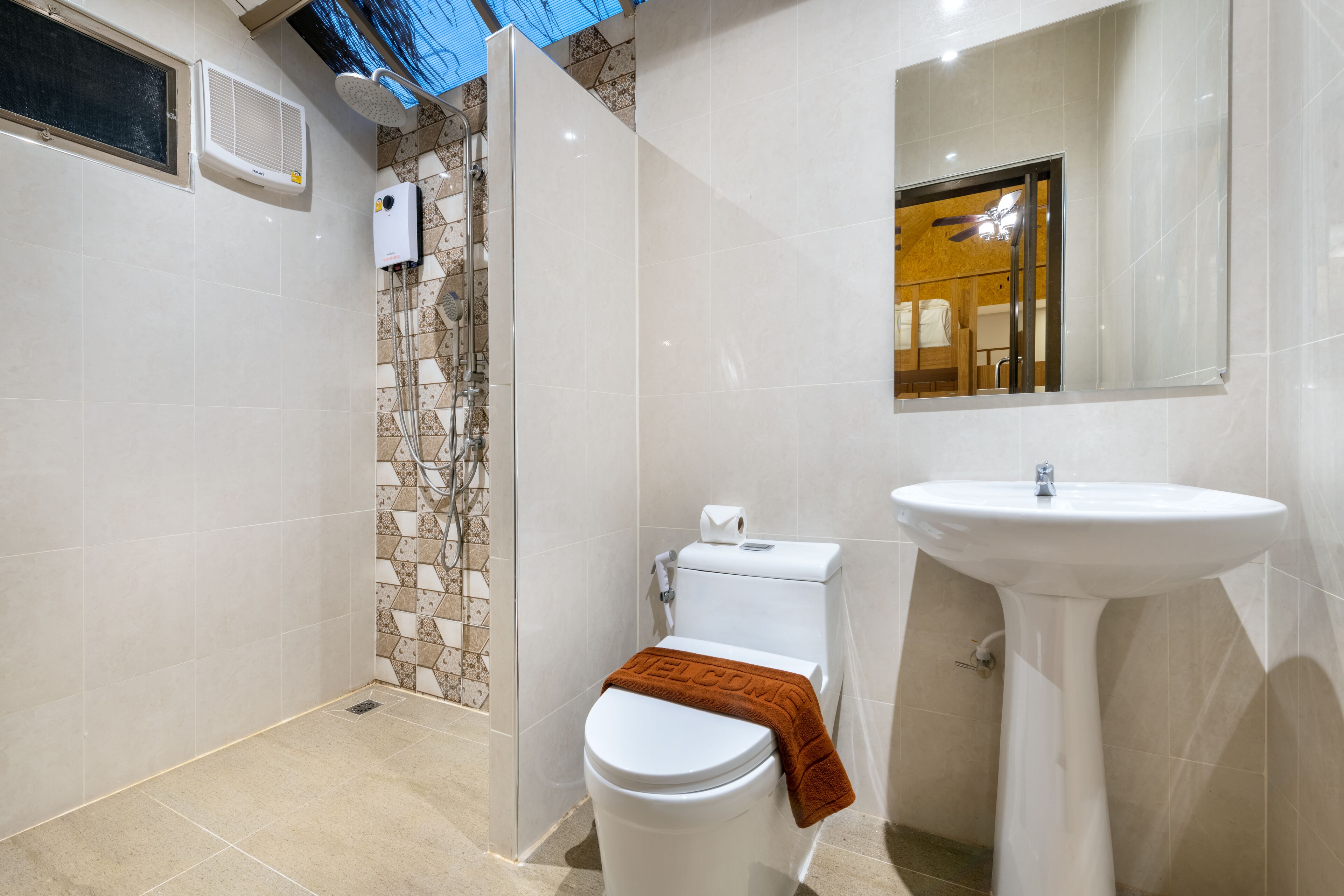 A modern bathroom with a shower, toilet, and sink.