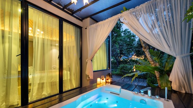 Un bagno moderno con una vasca da bagno ampia, uno spazio doccia in vetro e vista sull'esterno.