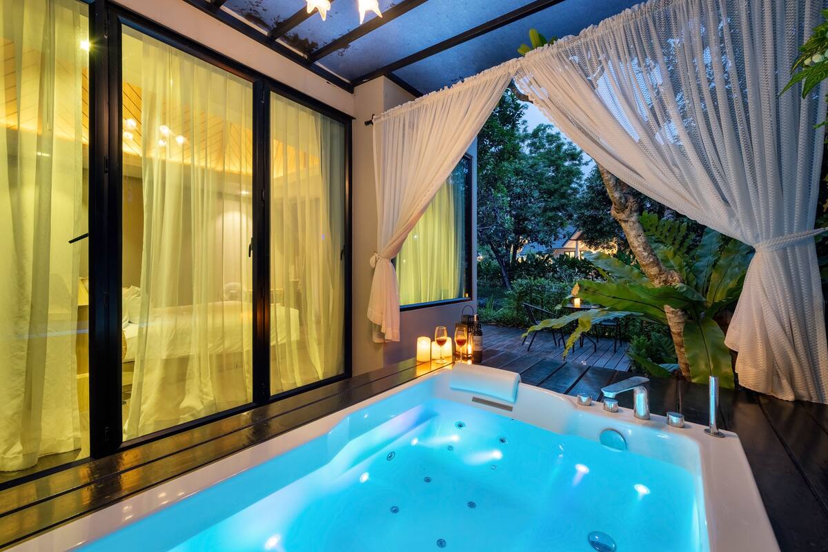 A modern bathroom with a large bathtub, a glass shower enclosure, and a view of the outdoors.
